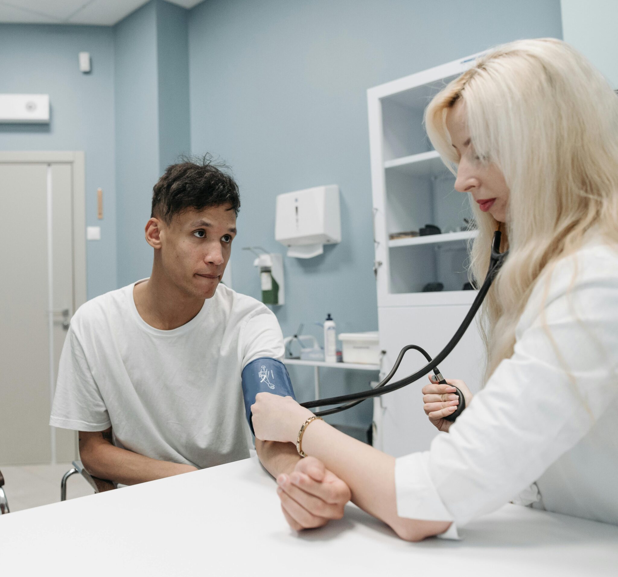 Doctor checking patient's blood pressure in clinic.